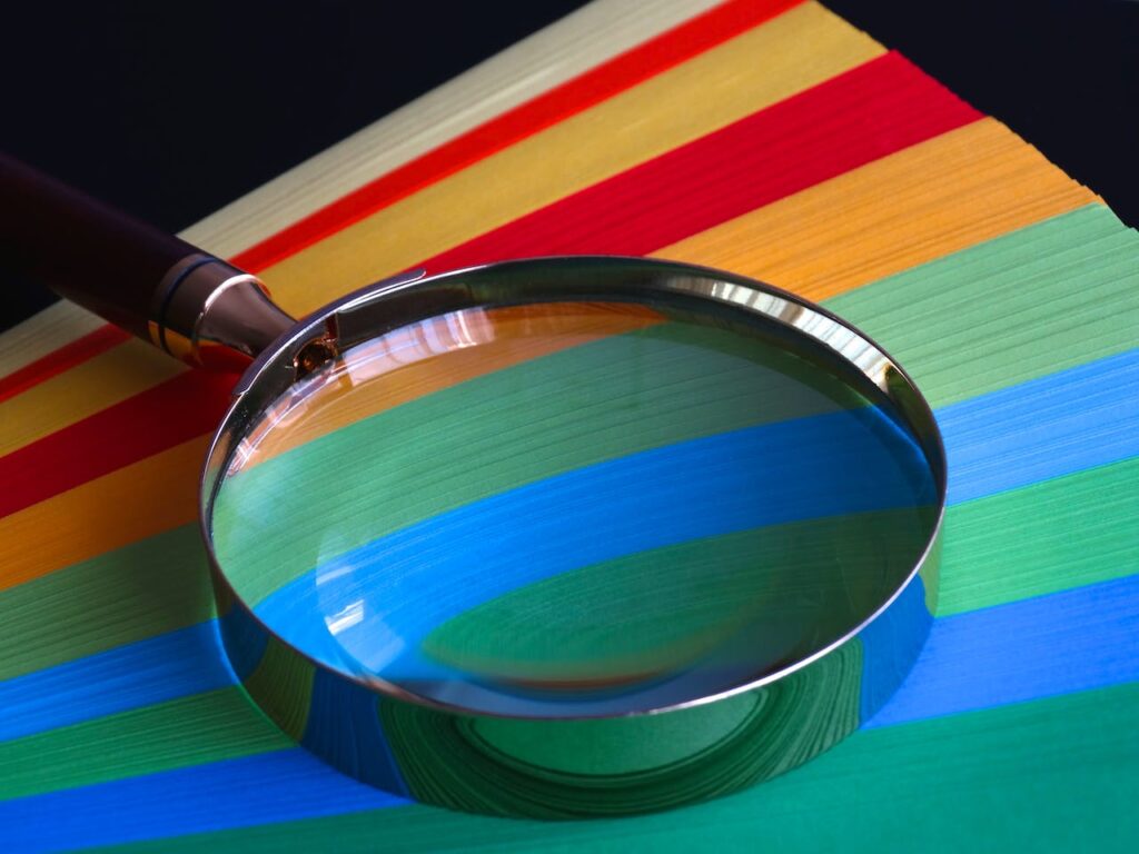 A magnifying glass on top of colorful materials