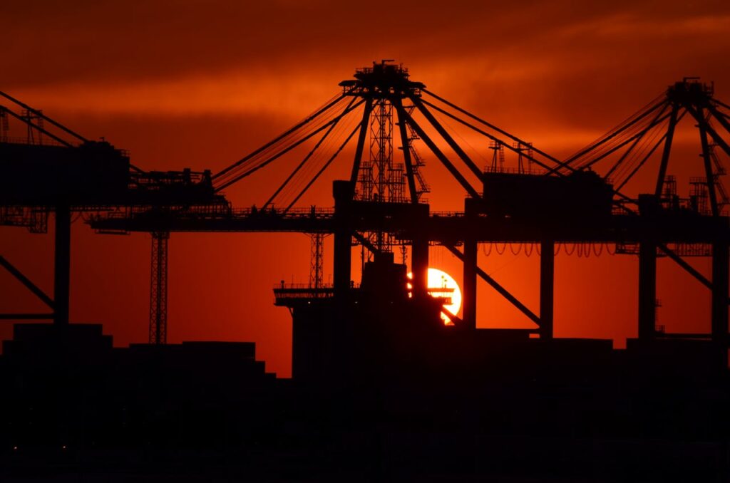 A photo of a cargo ship during sunset